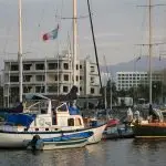 A harbor filled with lots of boats next to a tall building