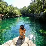 woman in black bikini standing on rock near river during daytime